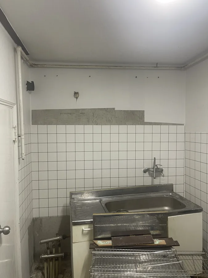 상부장이 철거되어 배관과 벽면만 남은 씽크대상부장교체 전 상태